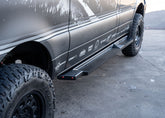 Side view of ROAMBUILT Flat Side Step in black textured aluminum, mounted on a Mercedes Sprinter, showing raised grip edge and lights.