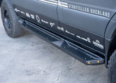 Front-to-back passenger side view of ROAMBUILT Flat Side Step on Mercedes Sprinter, showing black aluminum finish and integrated and small lights.