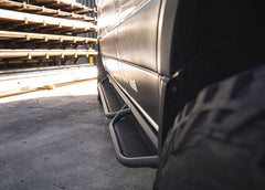 Top-down view of ROAMBUILT Passenger Side Tube Step on Mercedes Sprinter, showing perforated aluminum decking and tubular frame from front to back.