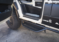 Driver side rear-to-front view of ROAMBUILT Mercedes Sprinter Side Step mounted beneath the van, highlighting full-length perforated aluminum decking for traction and visibility.