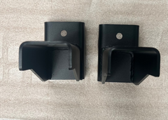 View looking down at a pair of ROAMBUILT replacement frame brackets for 2019+ Mercedes Sprinter 2WD and 3500 dually models, showing the flat mounting surfaces and bolt holes.