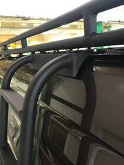 Close-up driver side view of a Mercedes Sprinter van showing the ROAMBUILT Straight Side Ladder mounted securely into the factory roof rail beneath the ROAMBUILT Safari 2.0 roof rack, highlighting the mounting brackets and hardware integration.