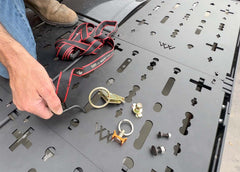 Top view showing ROAMBUILT roof rack deck panels with multiple mounting locations and various gear attachments for versatile roof storage.