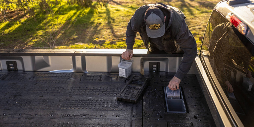 @expanded [XF6LF, XF7LF, XG10LF, XG5LF, XG9LF, XR5LF, XS4LF, XS5LF] A man storing nails in the cab-side stash bins in his 8' Load Floor, part of the Drawer System for 8 foot truck beds.