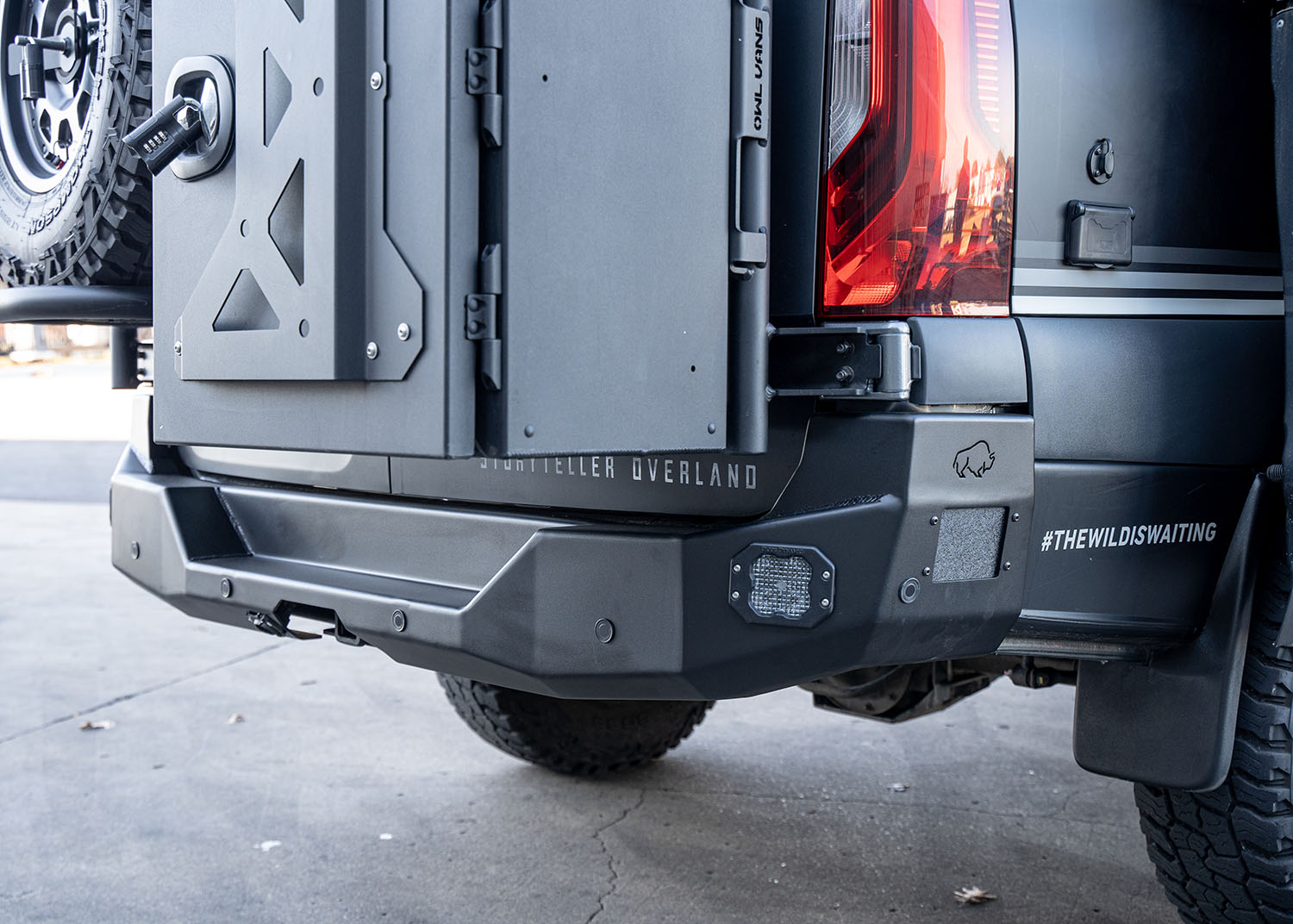 Side view of the full ROAMBUILT Rear Bumper on a Mercedes Sprinter van, showcasing its low-profile, full-width aluminum design with integrated step, flush-mounted lights, and compatibility with parking sensors and blind spot assist for both functionality and rugged performance.