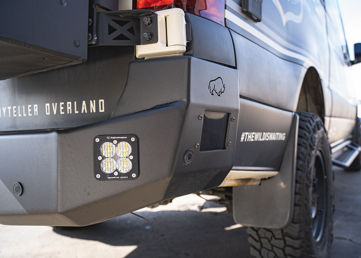 Partial passenger-side view of the ROAMBUILT Rear Bumper on a Mercedes Sprinter van, showcasing the flush-mounted light, integrated parking sensors, and precision welds—demonstrating the bumper’s high-quality craftsmanship and functional design.