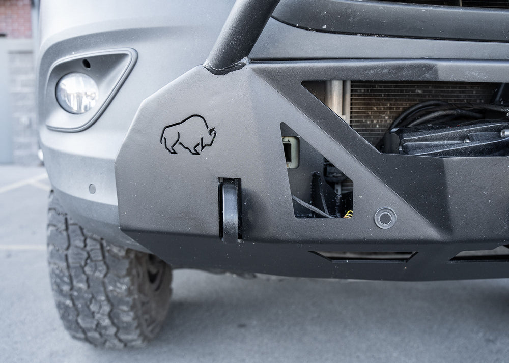 Front view of a Mercedes-Benz Sprinter van featuring the ROAMBUILT LoPro Front Bumper, highlighting integrated 1-inch thick steel shackle mounts and precision-machined sensor housings designed to accommodate factory parking sensors within the lightweight aluminum shell.