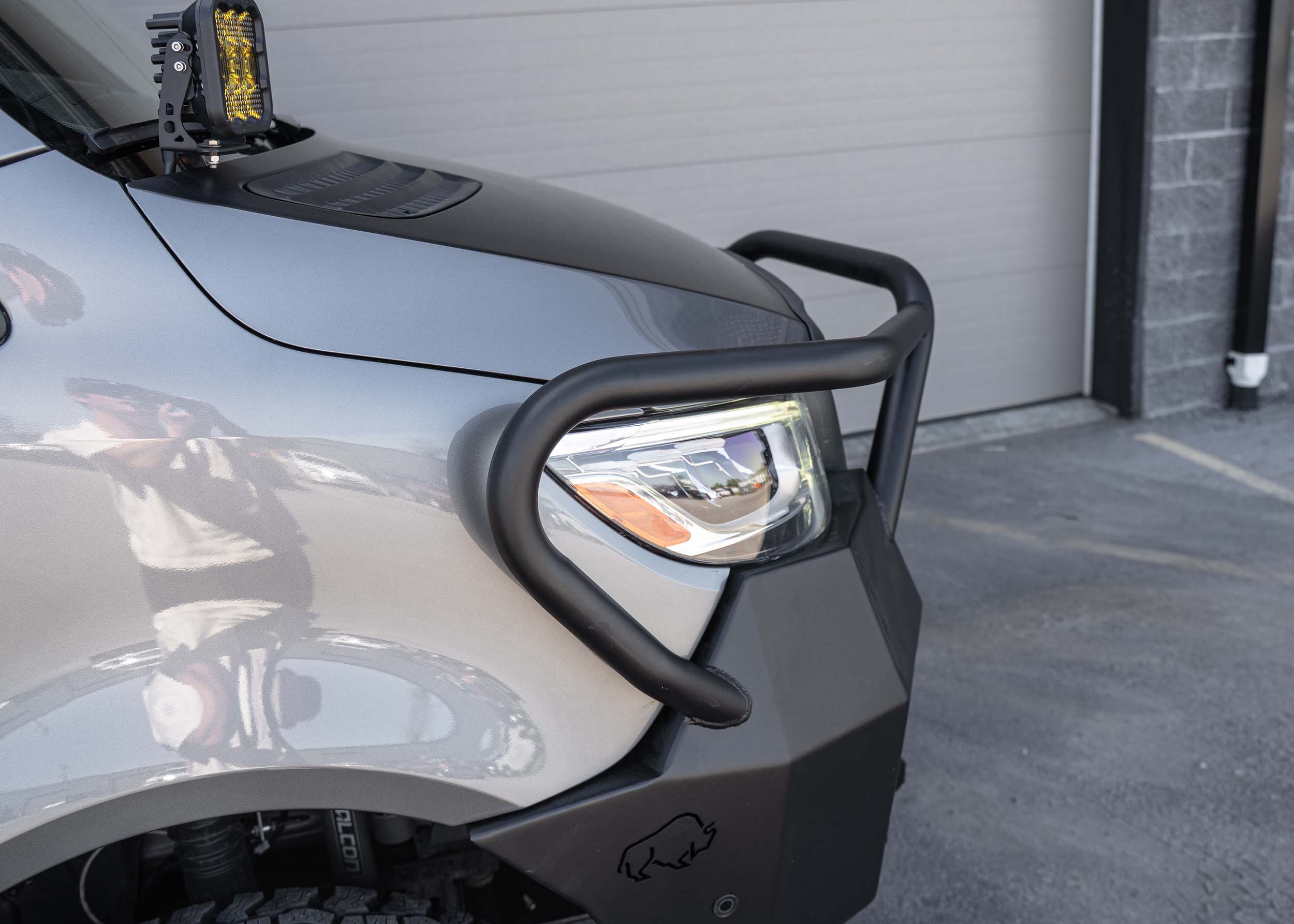 Top-side passenger view of a Mercedes Sprinter van featuring the Full Guard Front Bumper, showcasing its contoured fit, hybrid steel and aluminum build, and detailed design elements like light pockets and winch mount for robust, lightweight front-end protection