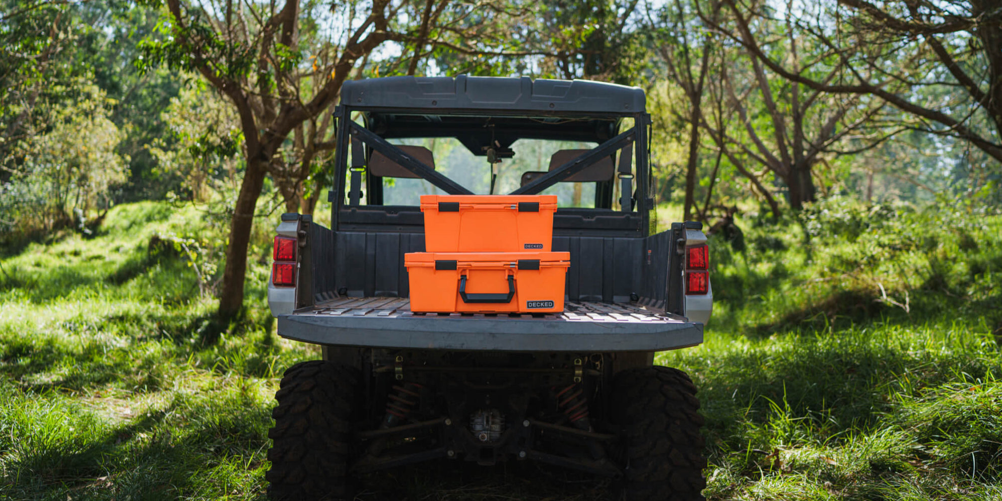[A0010-SIXR-ORG] @expanded The Blaze Orange Halfrack and Sixer stacked on the tailgate of a side-by-side in the woods.