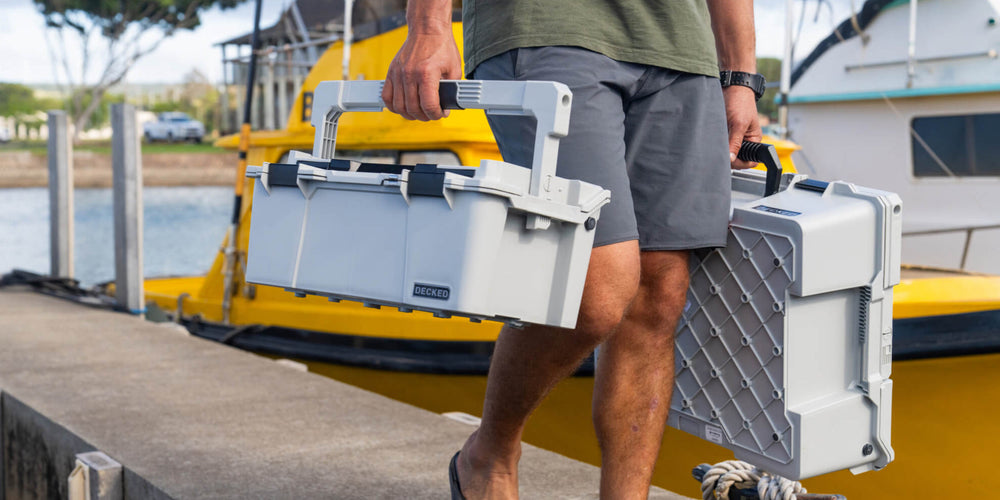 [A0010-SIXR-GRY] @expanded A man walking off the dock in a marina, carrying the Cool Gray Sixer D-co Case which stayed cool to the touch even after sitting in the sun all day.