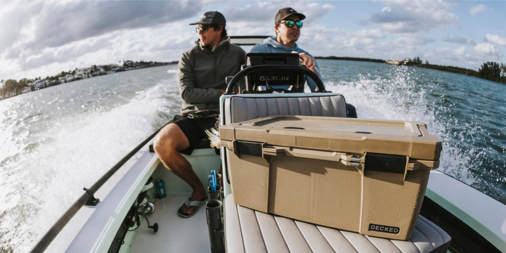 [A0010-SIXR-TAN] @expanded Two men headed out to fish in their boat, in front of them sits a Desert Tan Sixer D-co Case that carries all of their tackle for the day.