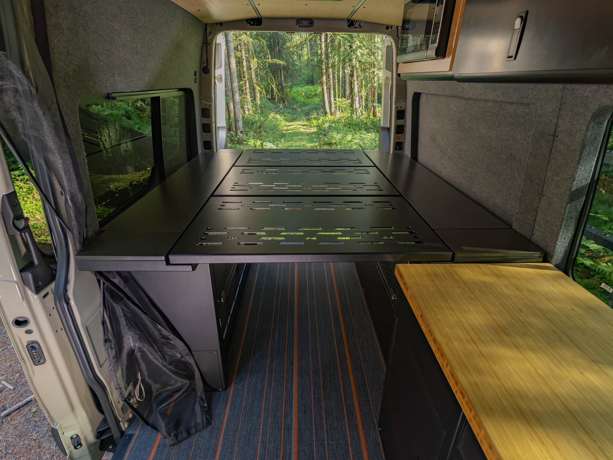 Modular Cabinet Bed System for Sprinter & Transit in North-South orientation installed in adventure van camping in the woods