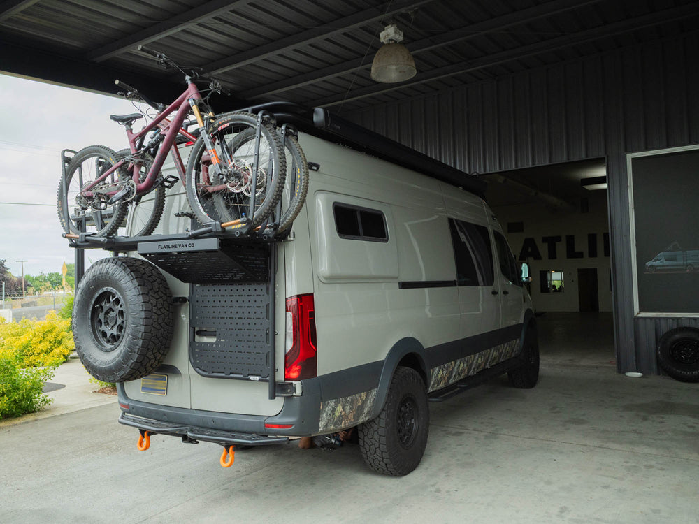 Sprinter 170 camper van carrying mountain bikes on rear door platform 