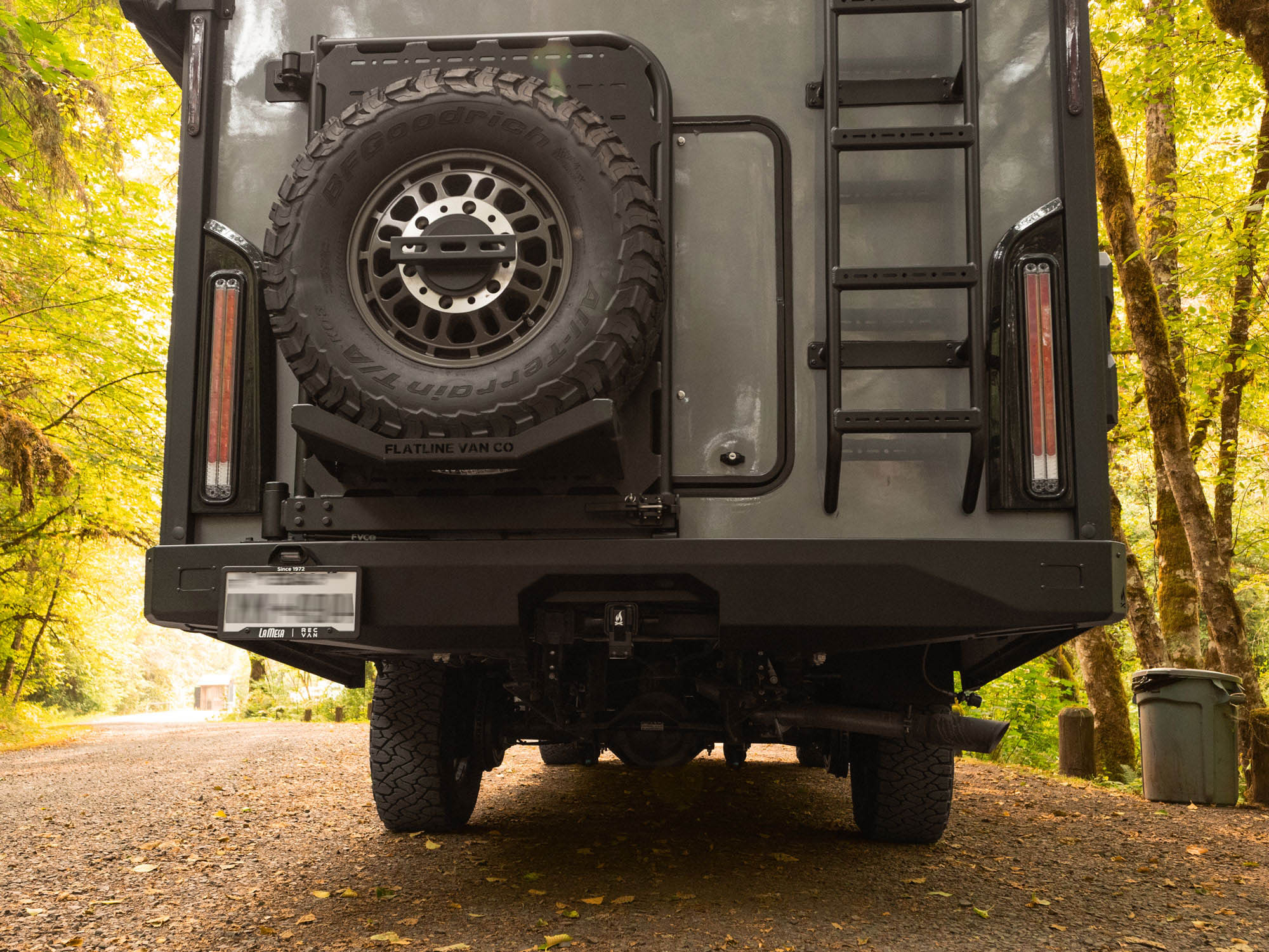 Closer view of installed Winnebago Ekko Rear Bumper for Transit and Sprinter, along with Rear Platform, Spare Tire Carrier Mount, and rear ladder