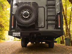 Closer view of installed Winnebago Ekko Rear Bumper for Transit and Sprinter, along with Rear Platform, Spare Tire Carrier Mount, and rear ladder