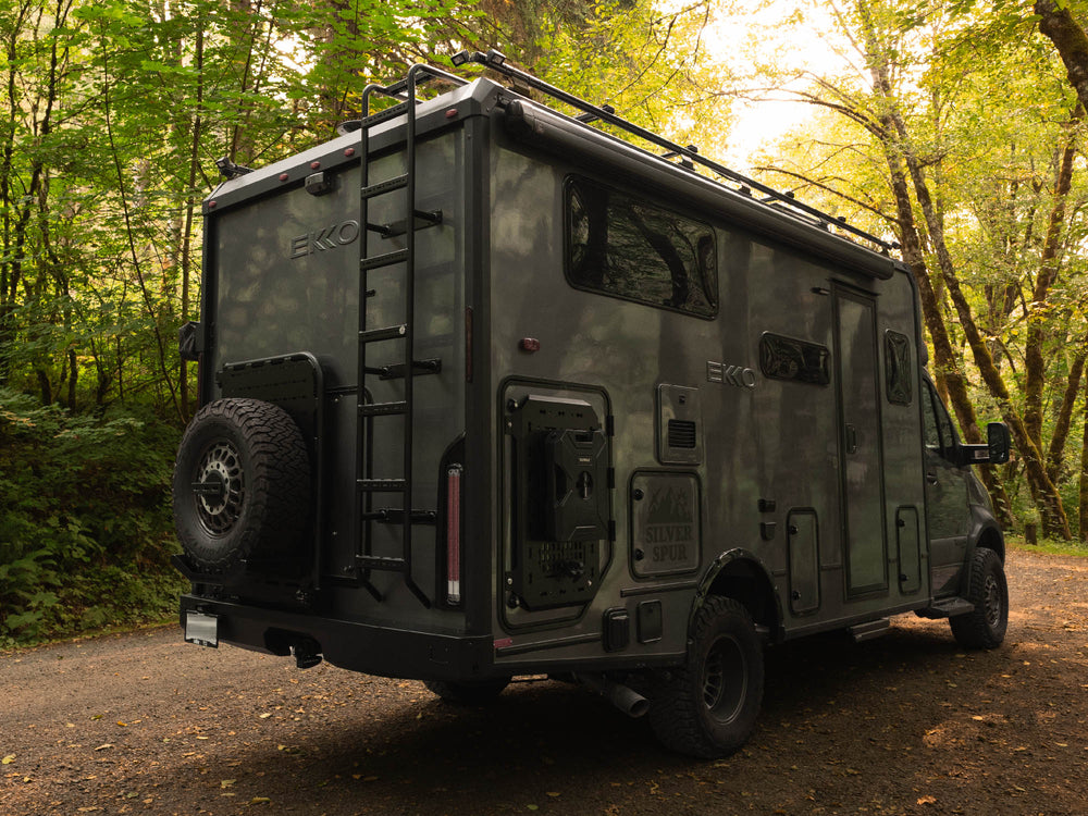 Winnebago Ekko parked in the woods with Winnebago Ekko Rear Bumper, Ladder, & Carrier Swing-Out System by FVC installed