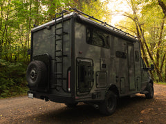 Winnebago Ekko parked in the woods with Winnebago Ekko Rear Bumper, Ladder, & Carrier Swing-Out System by FVC installed