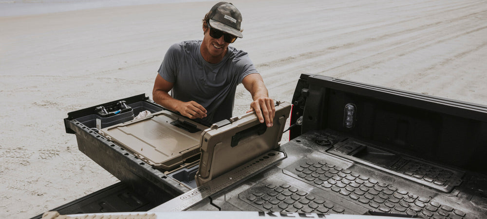@expanded [XF6, XF7, XG5, XG9, XG10, XR5, XS4, XS5] A man on a beach retrieving gear out of a D-co Case nested inside of his Drawer System.