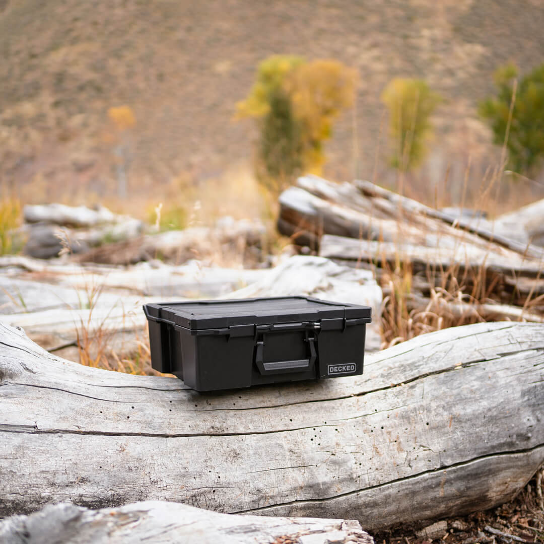 [A0020-HRAK-BLK] Black Halfrack 32 in the backcountry sitting on a log.