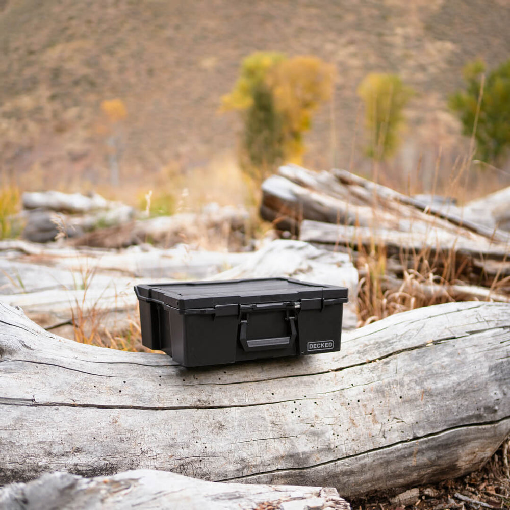 [A0020-HRAK-BLK] Black Halfrack 32 in the backcountry sitting on a log.