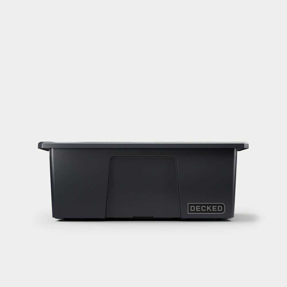 [A0041-DBIN-BLK] The front of one black Payloader bin, closed on a white background with a DECKED logo in the bottom right hand corner of the bin.