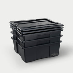 [A0040-DBIN-BLK] Three black Payloader bins nested together with the three lids stacked on top. 