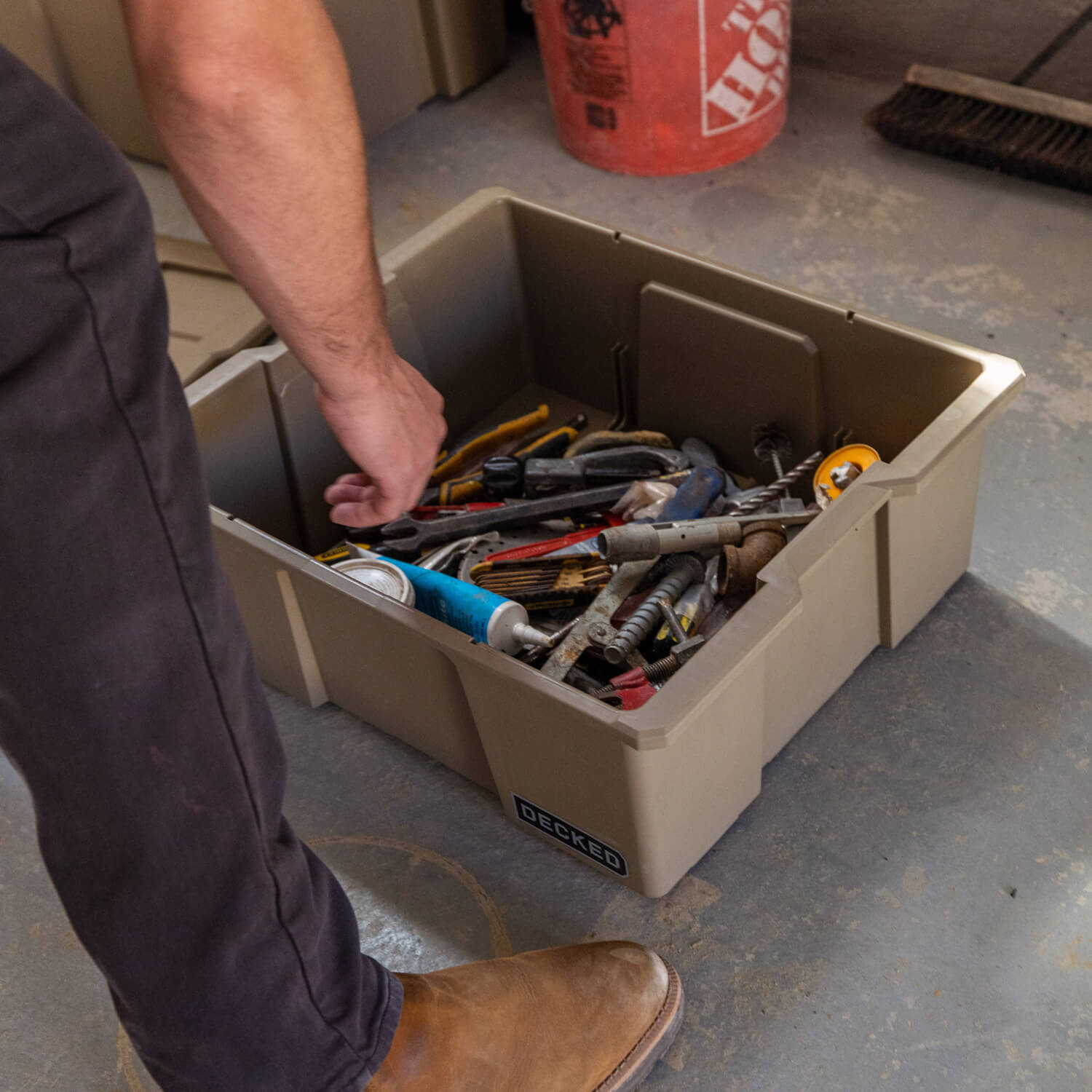 [A0041-DBIN-TAN, A0040-DBIN-TAN] A man in his garage, organizing hand tools in a desert tan Payloader Bin.