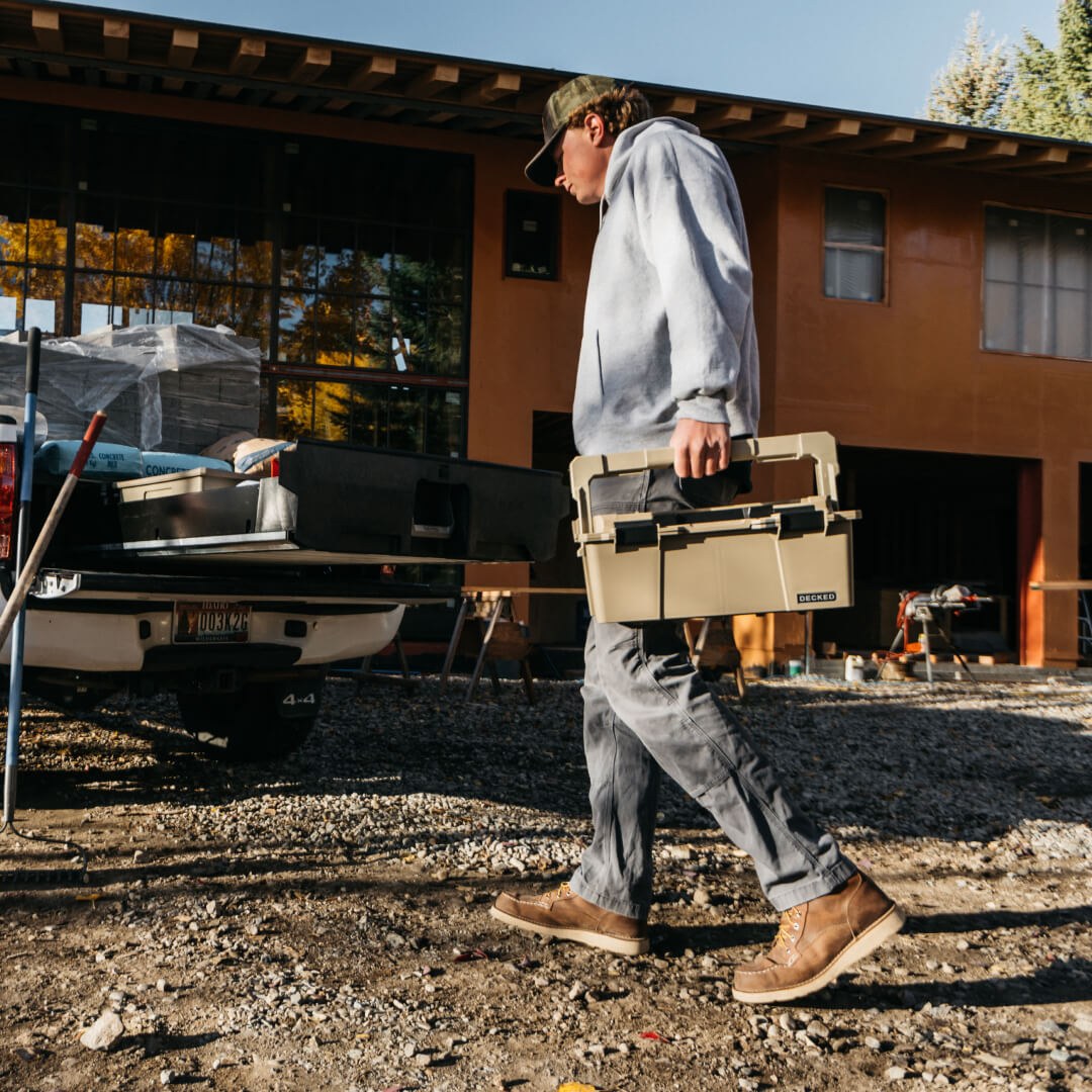 [A0010-SIXR-TAN] Man carrying a Desert Tan Sixer 16 around a construction jobsite