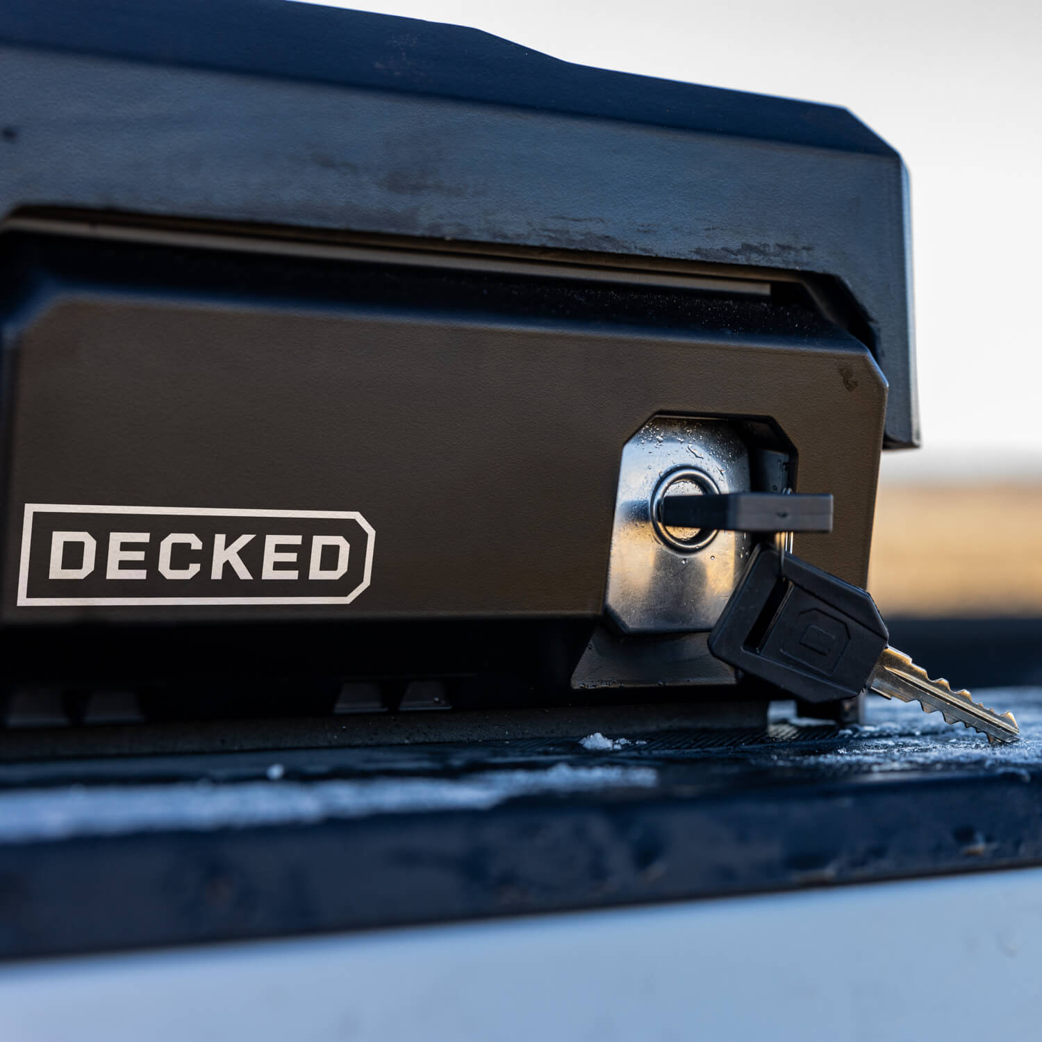 [DTB2-BLK, DTB2-TAN, DTB2T22-BLK, DTB2T22-TAN] Key inserted into the DECKED Tool Box lock on the driver side of a truck bed.