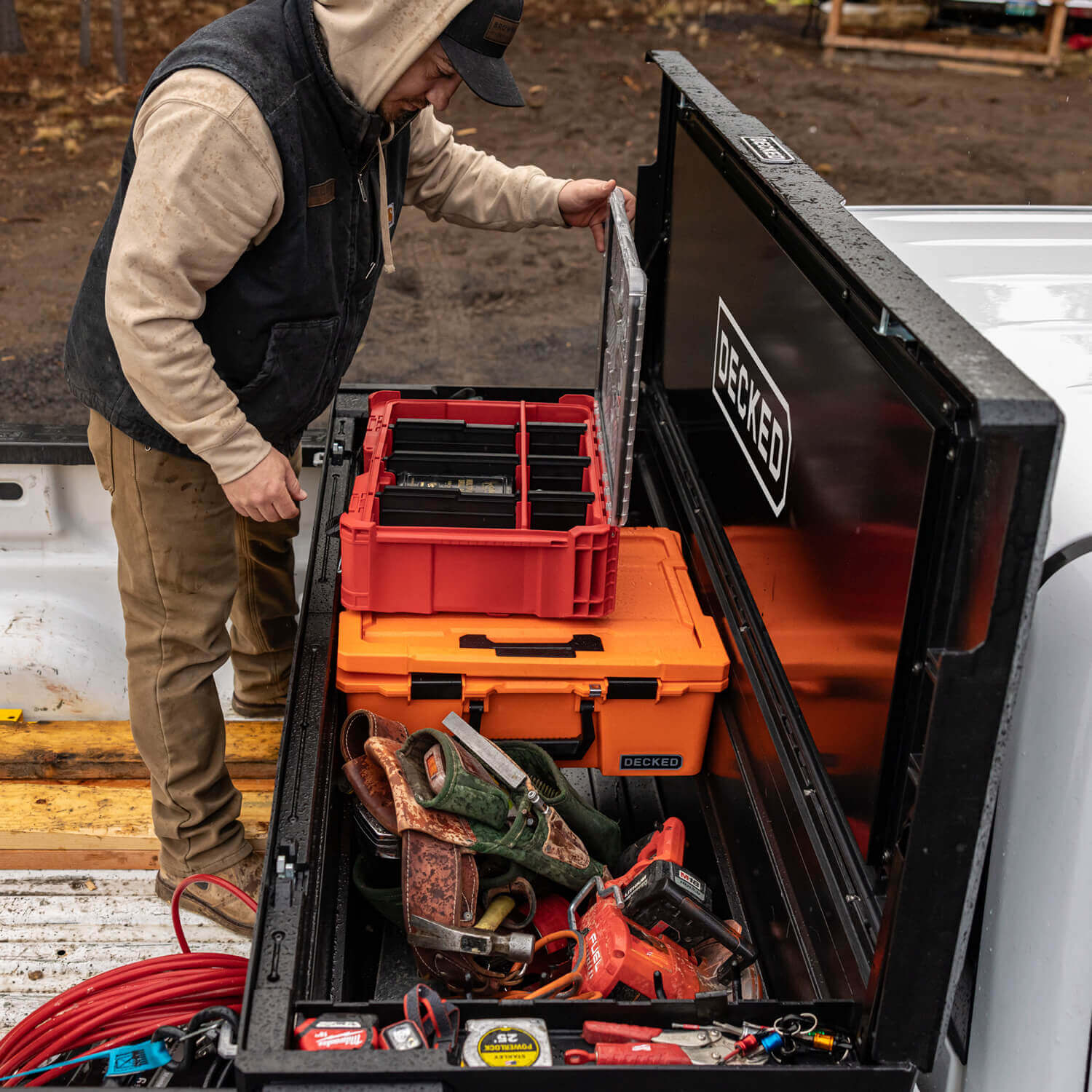 [DTB2-BLK, DTB2T22-BLK] Person organizing tools in a DECKED Tool Box truck bed organizer.