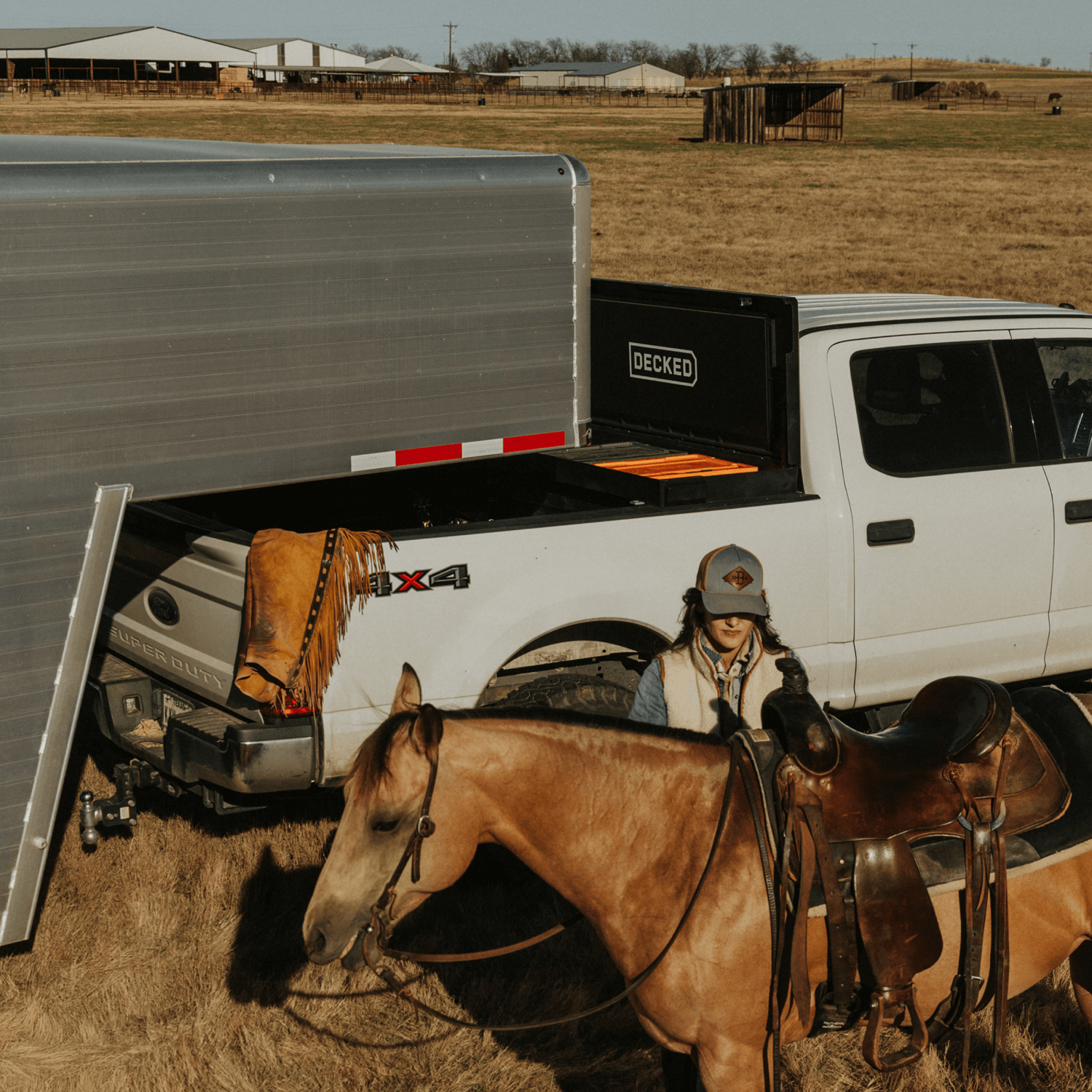 [DTB2-BLK, DTB2T22-BLK] Person with a horse and a truck with a DECKED Tool Box and gooseneck trailer in a rural setting