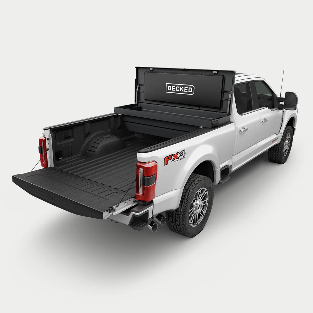 [google-black-tool-box] White pickup truck with a black DECKED Tool Box open in the bed.