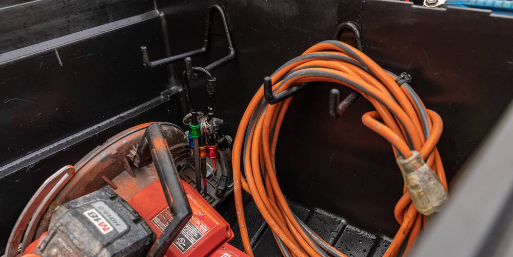 @expanded Orange extension cord coiled, hanging on a Tool Hook inside the Tool Box.